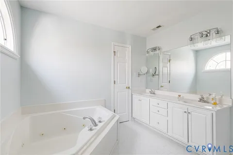 a bathroom with a bathtub a mirror a sink and vanity