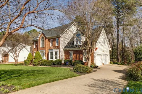a view of a house with a yard and large tree