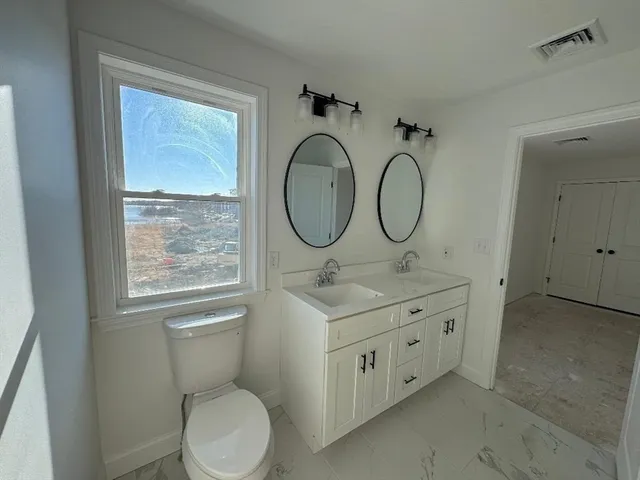 a bathroom with a toilet sink and mirror