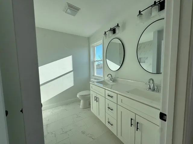 a bathroom with a double vanity sink and a mirror