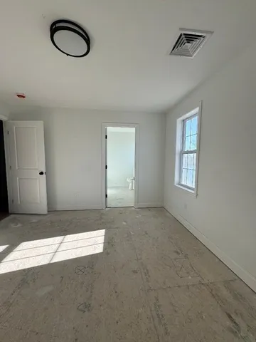 an empty room with windows and air conditioner