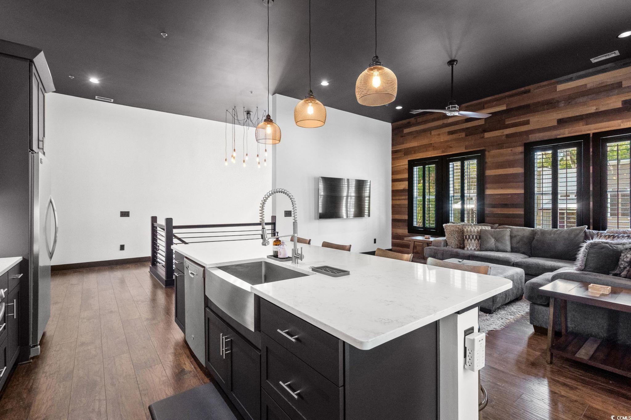 34 Shady Moss Loop, Unit 34 Murrells Inlet, SC 29576 - Photo 11 of 40 Kitchen featuring wood walls, dark cabinetry, pendant lighting, dark wood finished floors, and light stone countertops