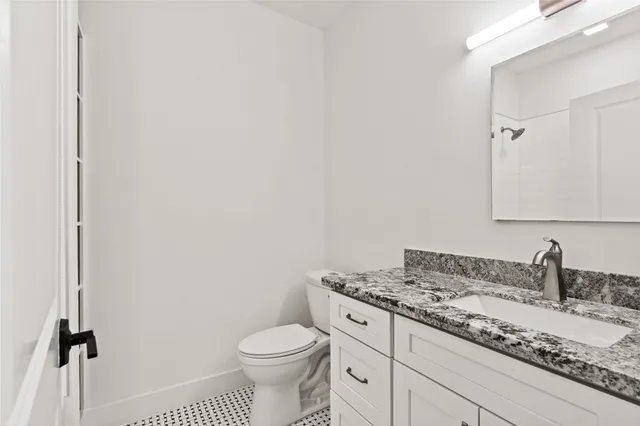 a bathroom with a granite countertop sink toilet and shower