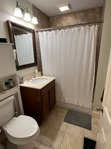 a bathroom with a sink vanity mirror and toilet