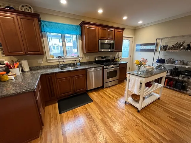 a kitchen with stainless steel appliances granite countertop a sink stove and wooden cabinets