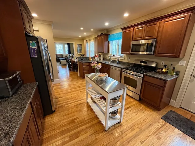 a kitchen with stainless steel appliances granite countertop a refrigerator stove microwave and sink