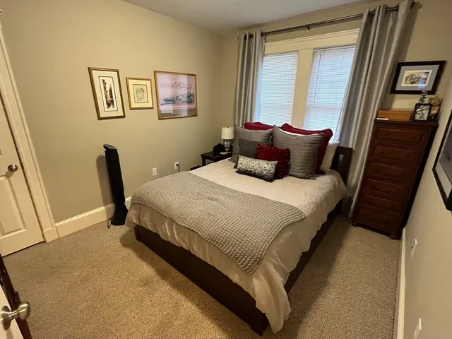a large bed sitting in a bedroom next to a window