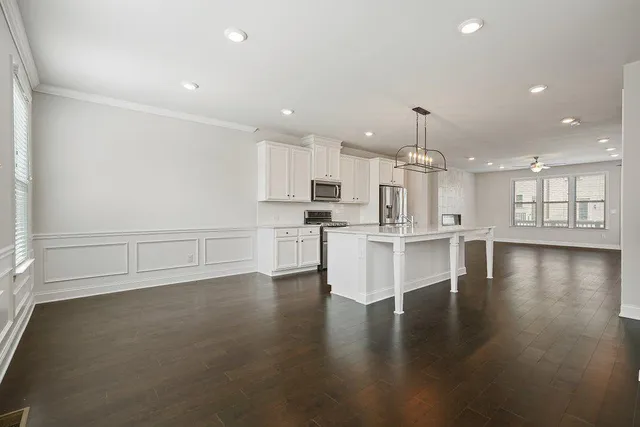 an empty room with wooden floor and a ceiling fan