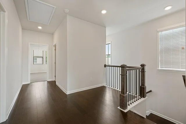 an empty room with windows and ceiling fan