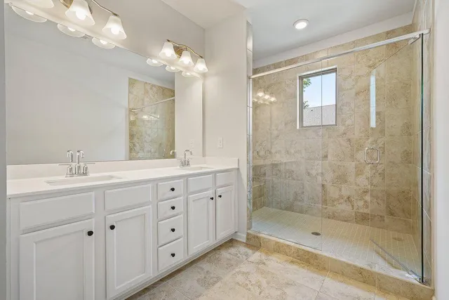 a bathroom with a double vanity sink toilet and shower