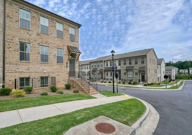 a view of a big building with a yard and plants