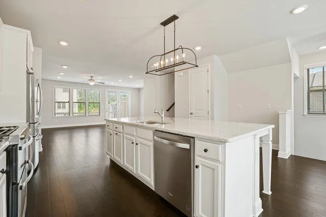 a kitchen with stainless steel appliances granite countertop a stove a sink and a refrigerator