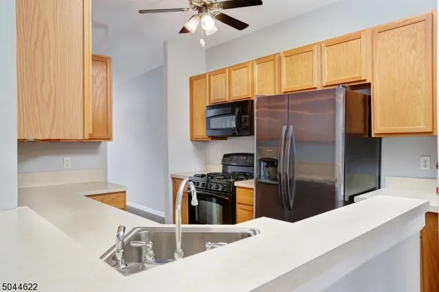 a kitchen with stainless steel appliances wooden cabinets a refrigerator and a sink