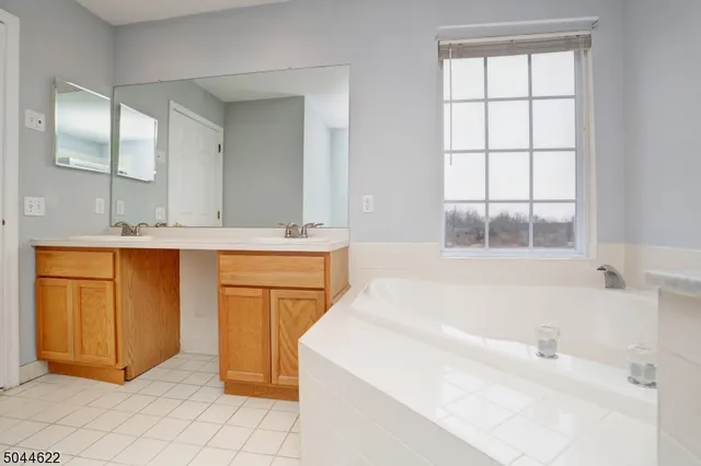 a bathroom with a tub sink and mirror