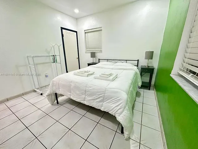 a bedroom with a bed and a mirror on dresser