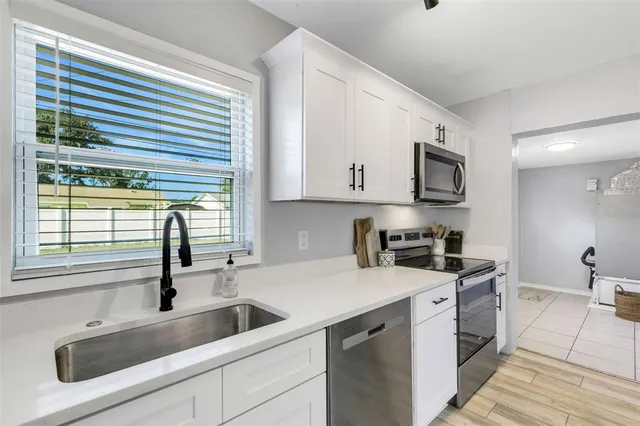 a kitchen with stainless steel appliances granite countertop a sink and a stove