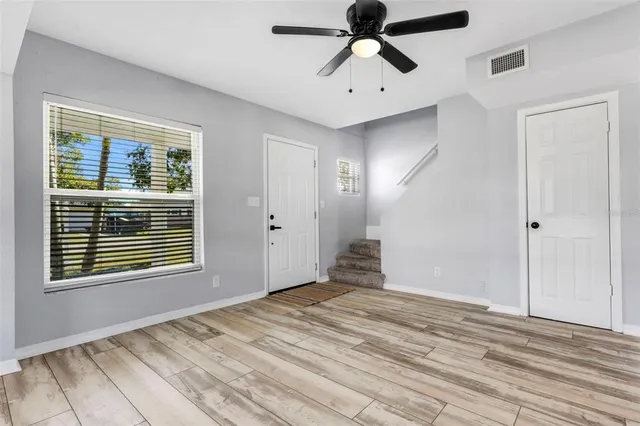 a view of empty room with window and ceiling fan