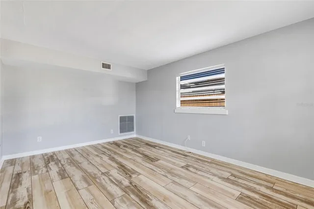 a view of empty room with wooden floor