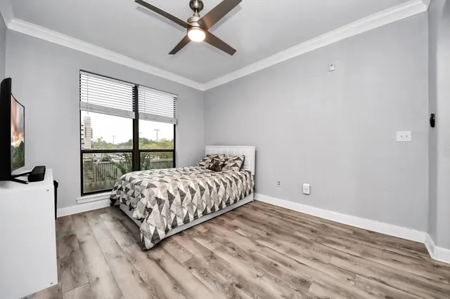 a bedroom with a large bed and a chandelier fan