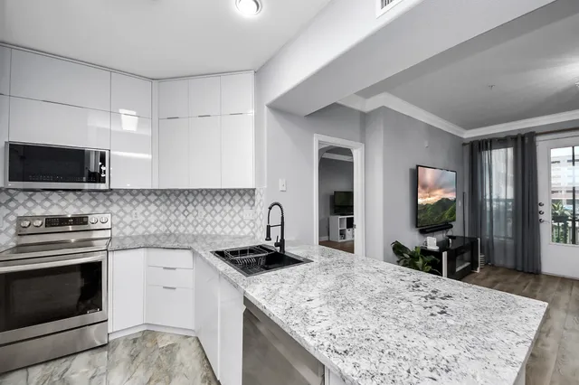 a kitchen that has a sink a stove and chairs