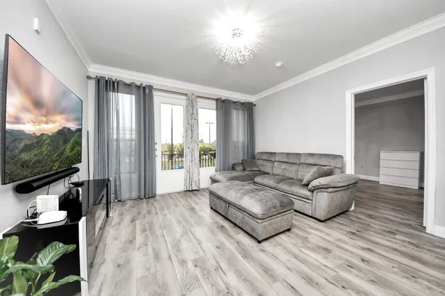 a living room with furniture and a dining table with kitchen view