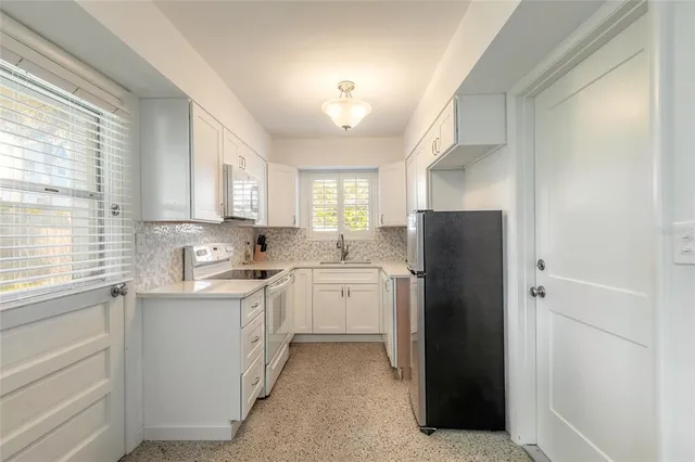 a kitchen with a refrigerator sink and cabinets