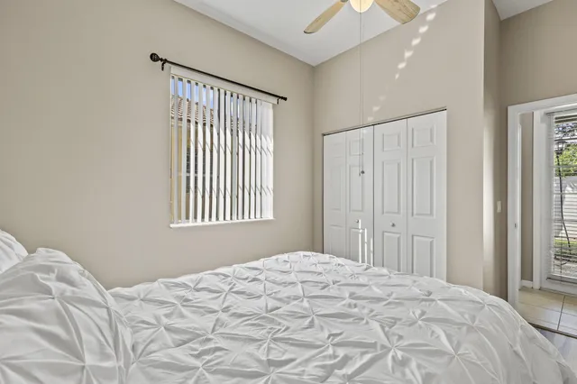 front view of a house with a yard and palm trees