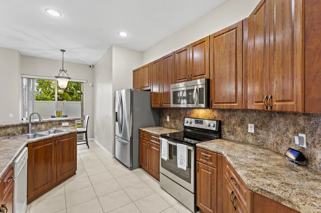 a kitchen with kitchen island granite countertop stainless steel appliances a stove sink and microwave