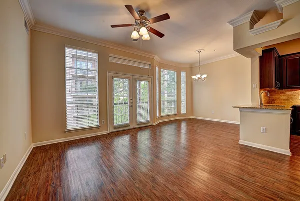 a view of an empty room with window and wooden floor