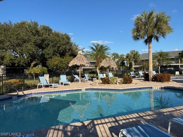 1220 Commonwealth Circle, Unit M206 Naples, FL 34116 - Photo 8 of 8 a view of a swimming pool with a table and chairs