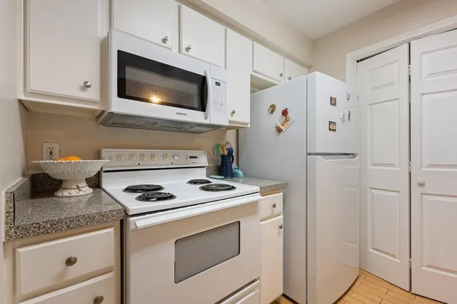 a kitchen with granite countertop cabinets stainless steel appliances and a counter space