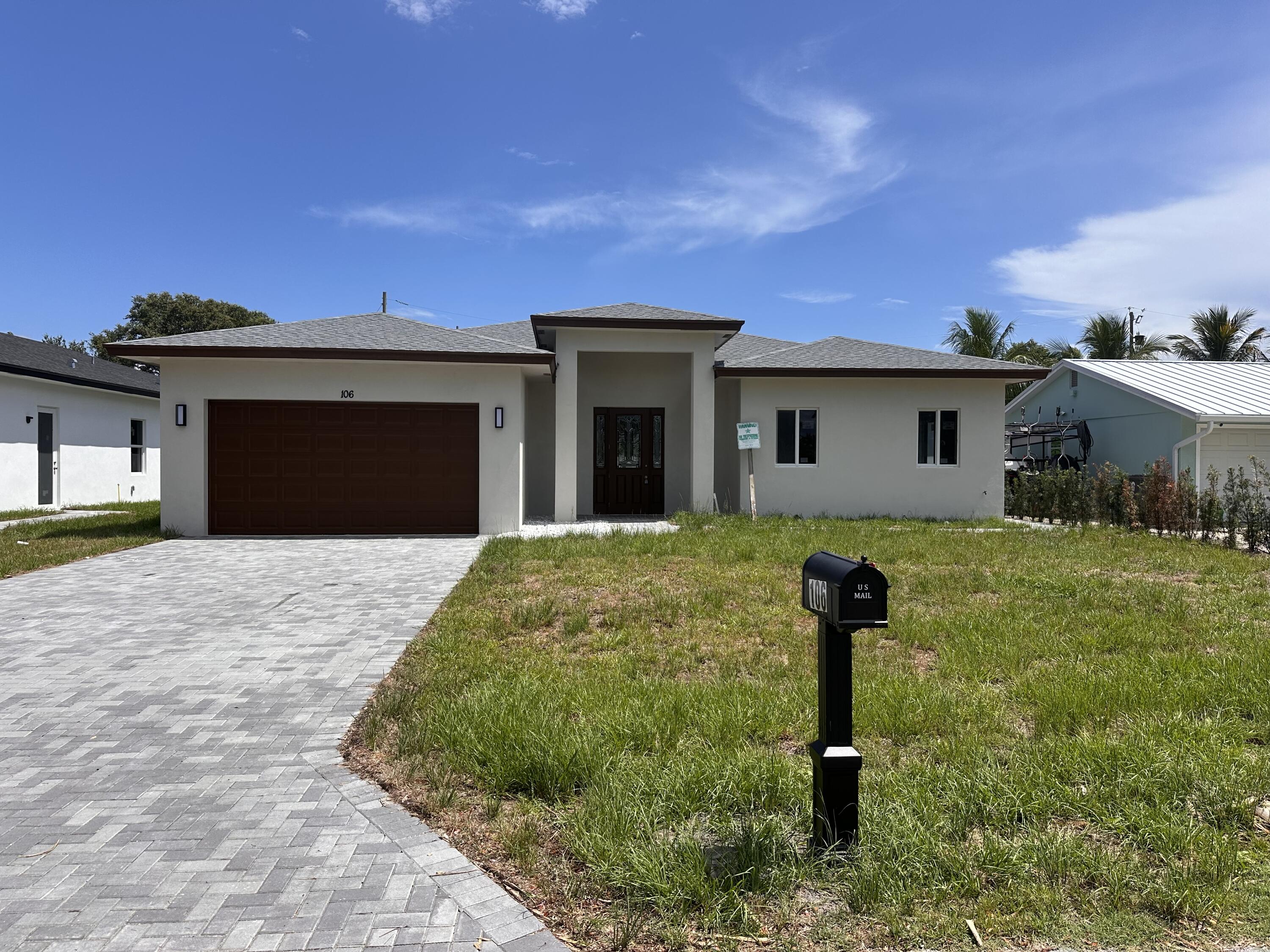 106 Northview Drive Jupiter, FL 33458 - Photo 1 of 13 a front view of a house with garden