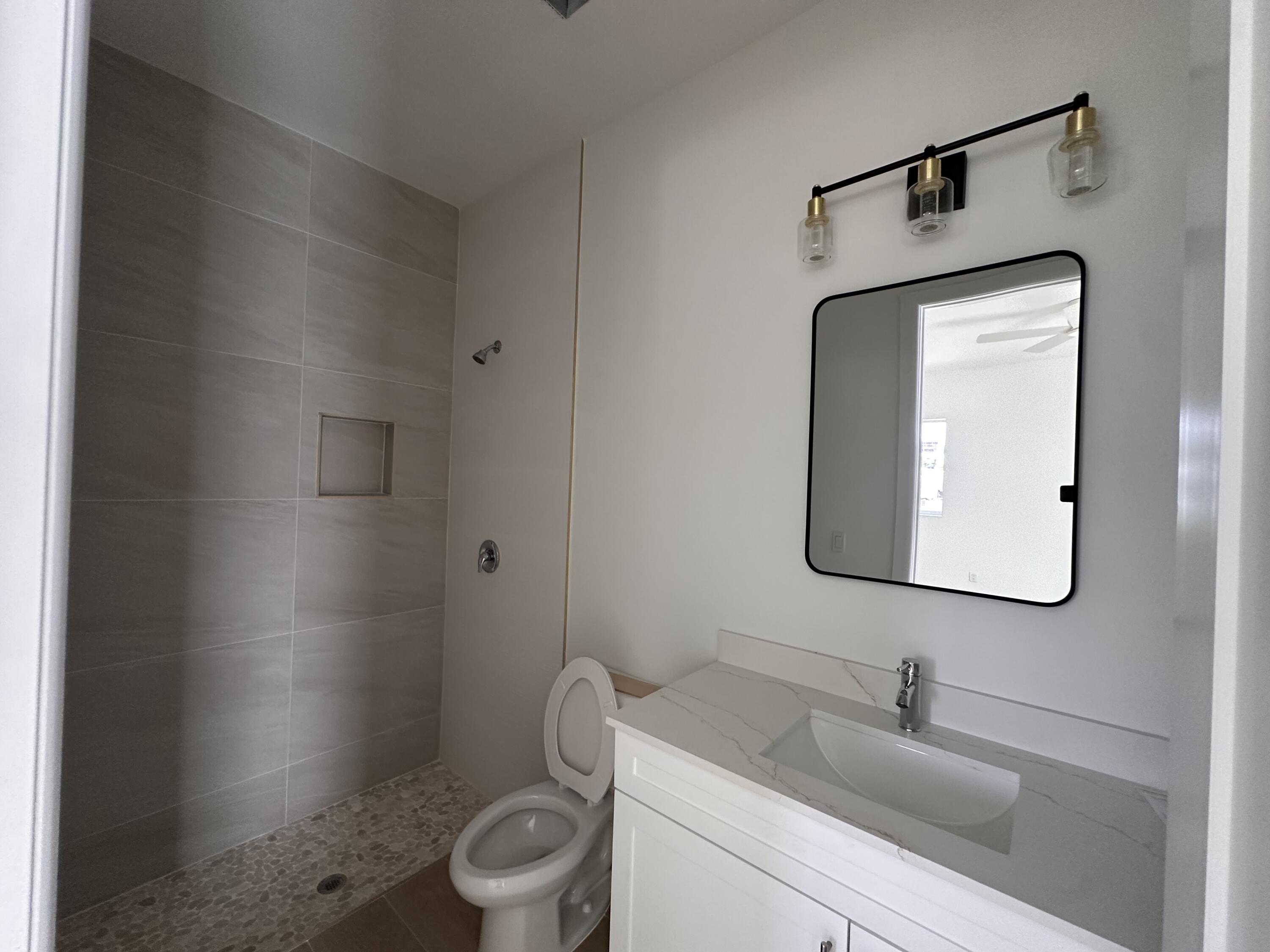 106 Northview Drive Jupiter, FL 33458 - Photo 13 of 13 a bathroom with a toilet sink and mirror