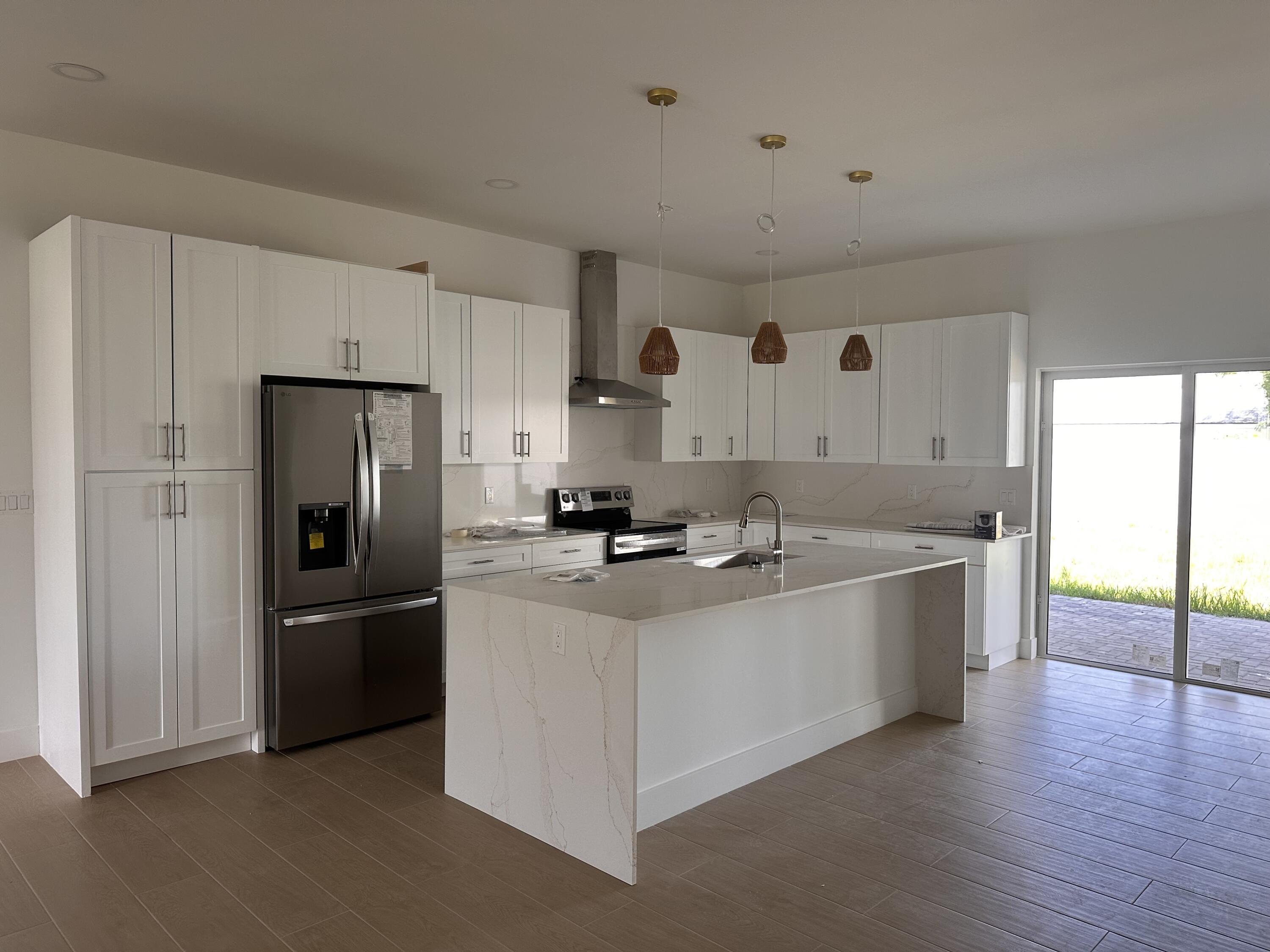106 Northview Drive Jupiter, FL 33458 - Photo 2 of 13 a large kitchen with stainless steel appliances a sink and a refrigerator