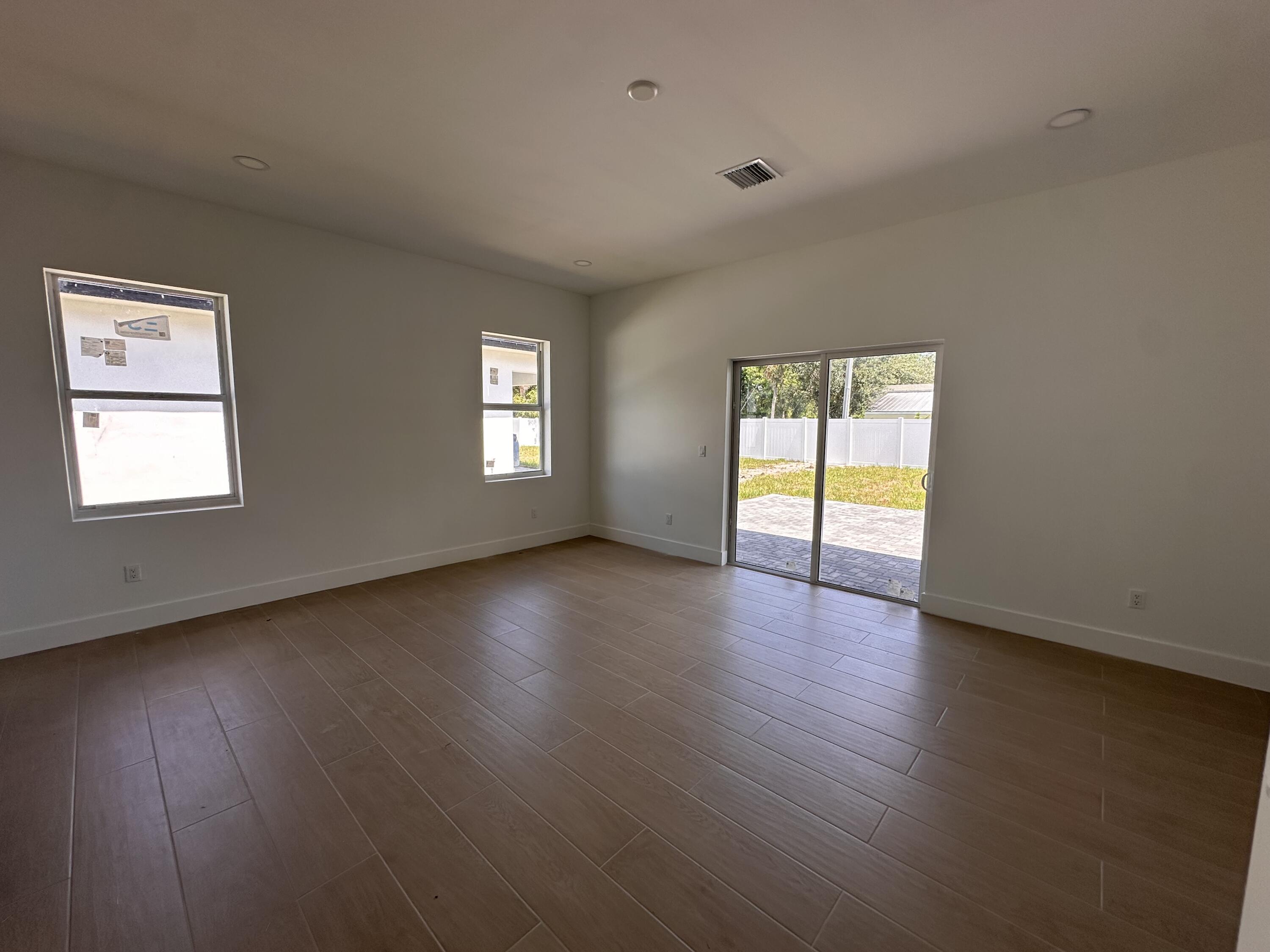 106 Northview Drive Jupiter, FL 33458 - Photo 4 of 13 a view of an empty room with wooden floor and window