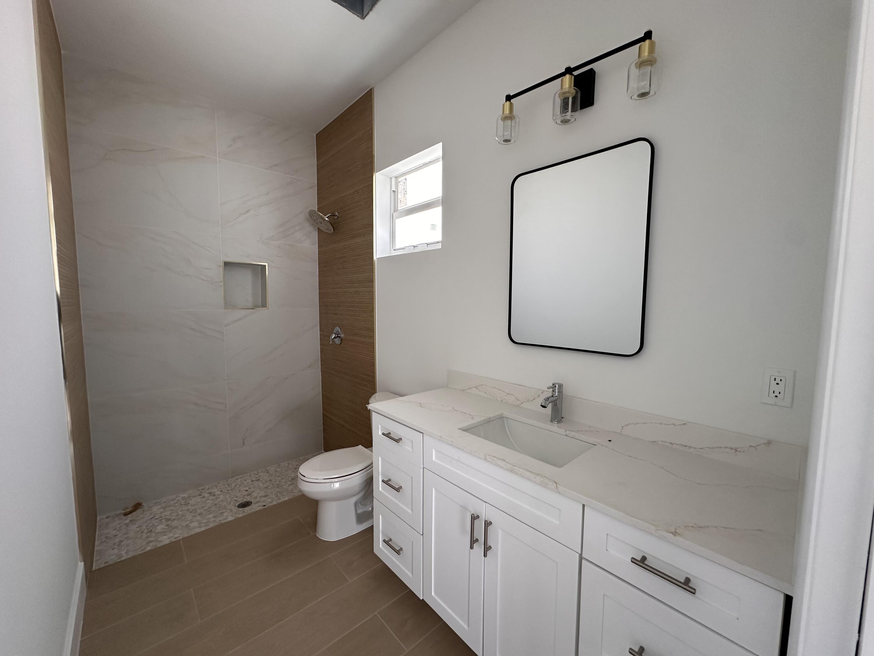 106 Northview Drive Jupiter, FL 33458 - Photo 5 of 13 a bathroom with a toilet sink and mirror