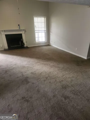 an empty room with a fireplace and windows