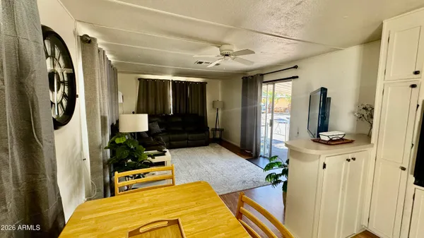 a very nice looking dining room with wooden floor and a refrigerator