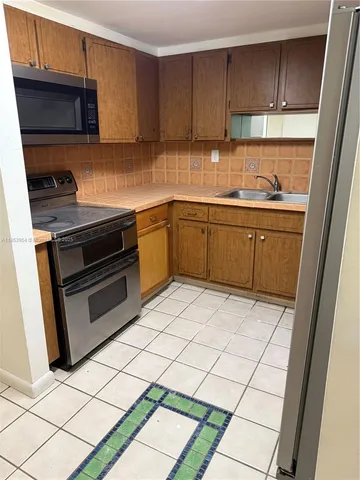 a kitchen with stainless steel appliances granite countertop a refrigerator and a stove