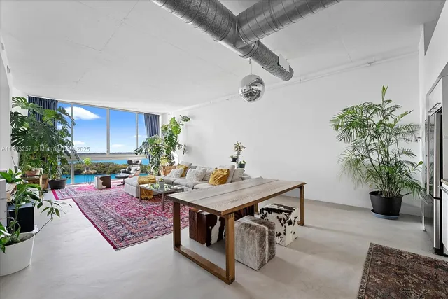 a living room with furniture and potted plants