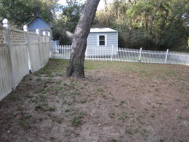 a view of a small yard and a wooden fence