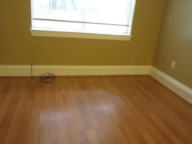 a view of a room with wooden floor and a window