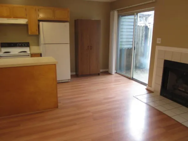 a view of a kitchen with fridge and wooden floor