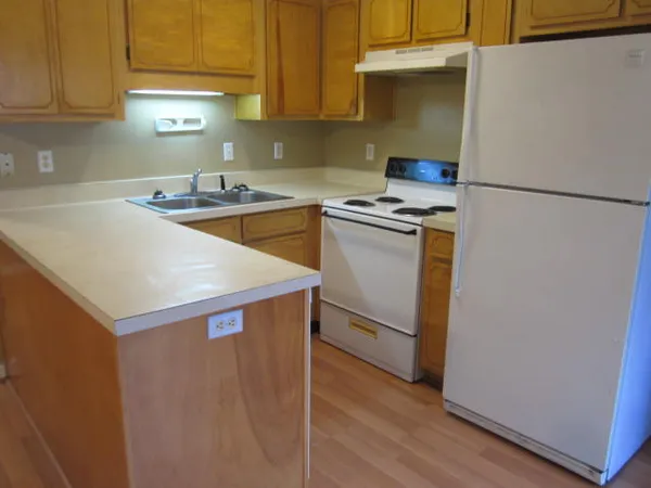 a kitchen with stainless steel appliances a sink a stove a refrigerator and cabinets