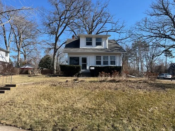 a front view of a house with a yard covered in snow