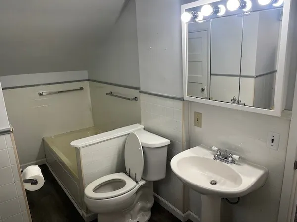 a bathroom with a toilet sink and mirror