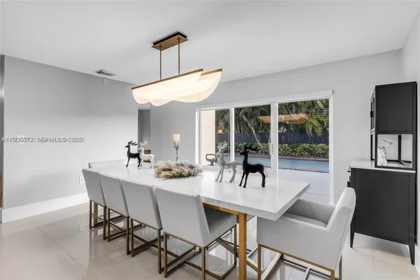 a dining room with furniture a chandelier and window