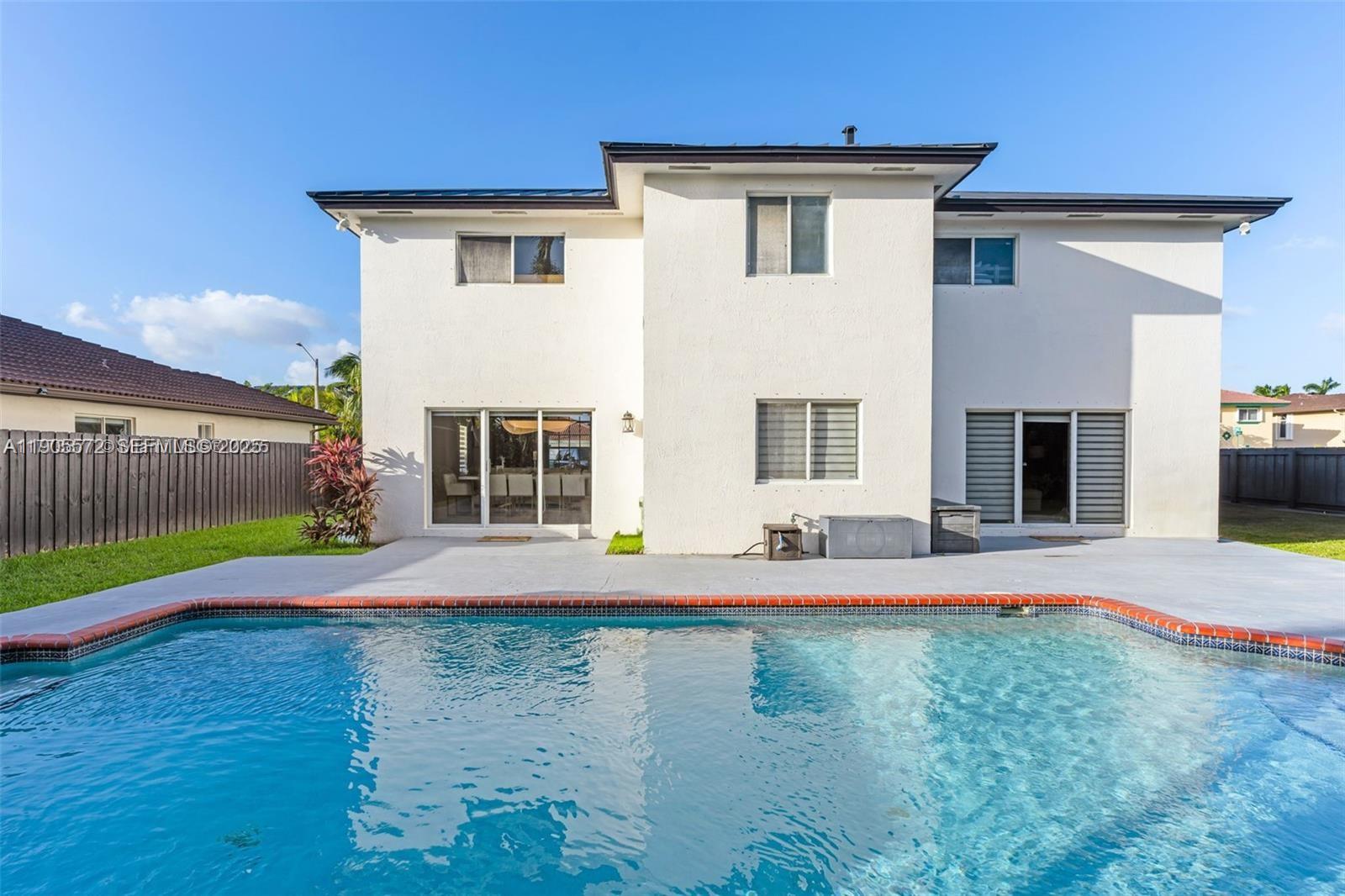 14206 Southwest 164th Terrace Miami, FL 33177 - Photo 42 of 58 a front view of a house with a yard and garage