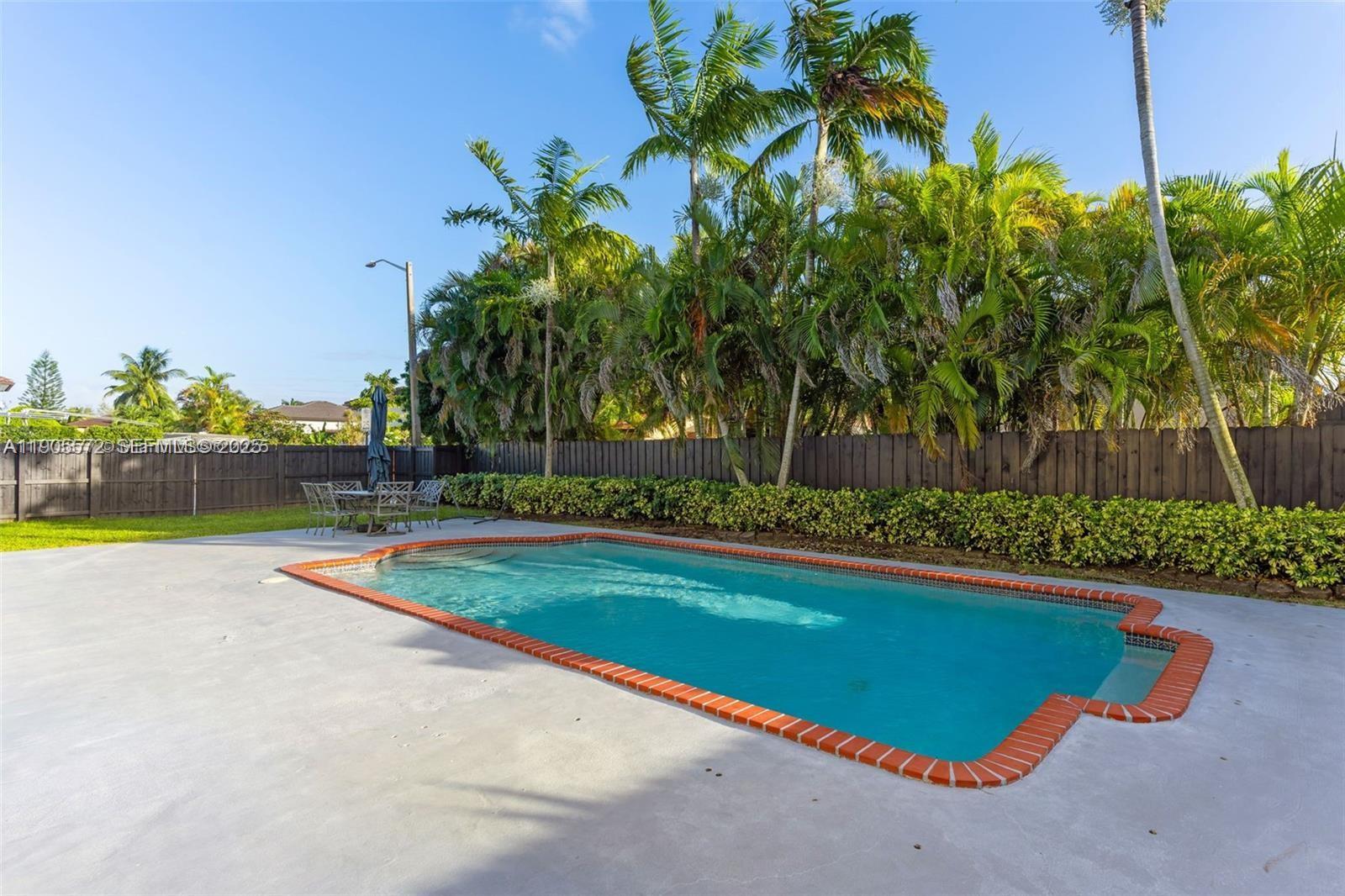 14206 Southwest 164th Terrace Miami, FL 33177 - Photo 44 of 58 a view of a swimming pool with a yard and plants