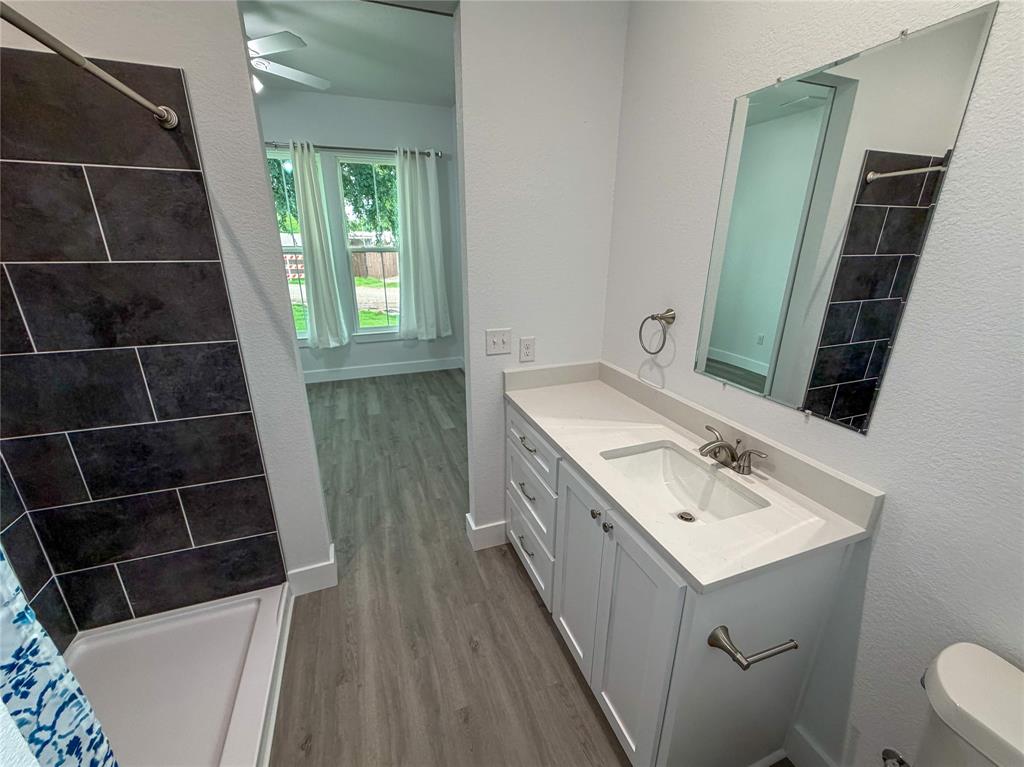 4200 Williams Road Bellmead, TX 76705 - Photo 16 of 22 a bathroom with a sink a toilet and a mirror